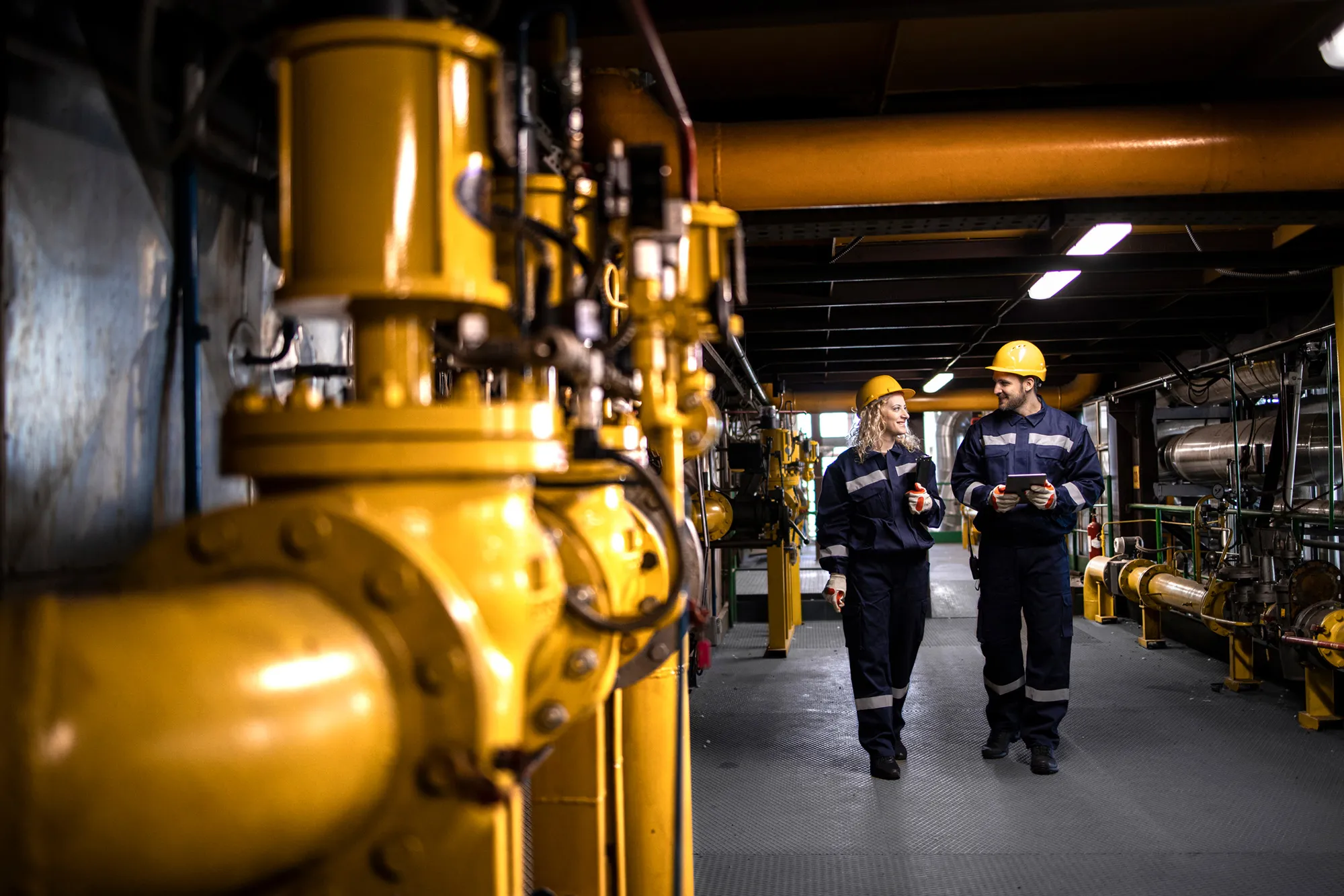 Two workers in coveralls at an industrial plant — representing the industries Sustrio works with.
