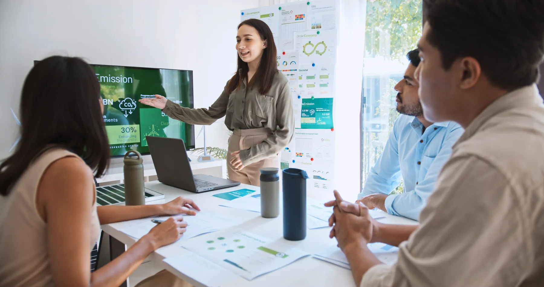A team meeting reviewing ESG plans on a laptop.